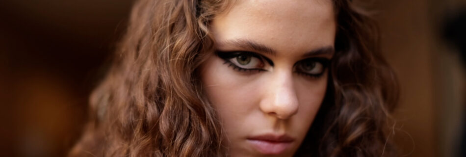 Close-up of model with bold black graphic eyeliner by Pat McGrath backstage at Louis Vuitton SS23.