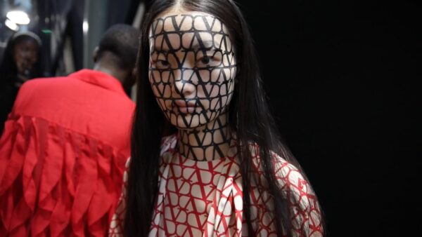 model backstage at Valentino show with Valentino graphic logos